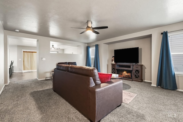 carpeted living room featuring a textured ceiling and ceiling fan