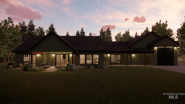 back house at dusk with a yard and an outdoor hangout area