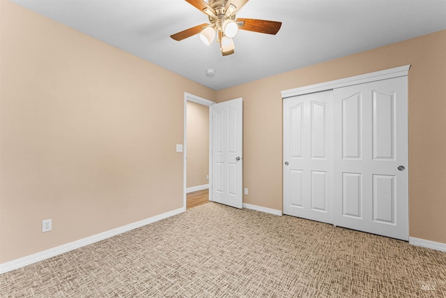 unfurnished bedroom featuring ceiling fan, a closet, and light carpet