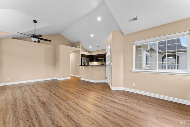 unfurnished living room with light wood-type flooring, ceiling fan, and vaulted ceiling