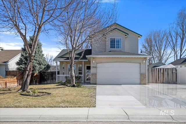 traditional-style house with covered porch, brick siding, fence, and a front lawn