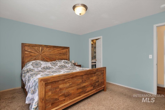 carpeted bedroom featuring a textured ceiling and baseboards