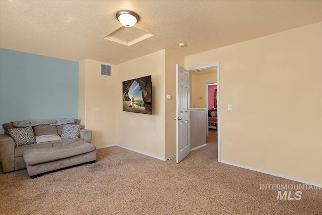 living room with carpet floors, baseboards, visible vents, and a textured ceiling