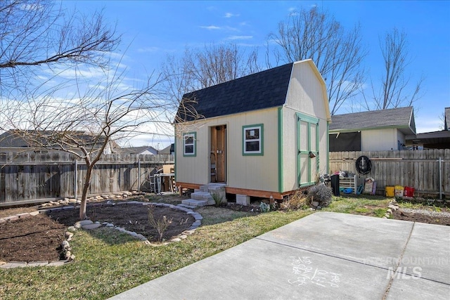 view of outbuilding with entry steps, an outdoor structure, and a fenced backyard