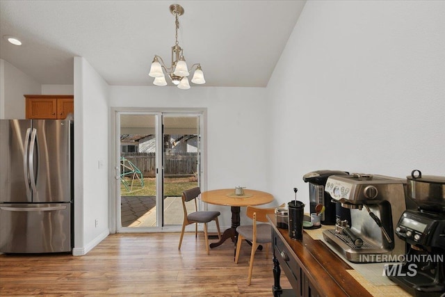 dining area featuring a chandelier, baseboards, and light wood-style floors