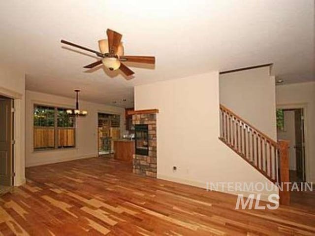 empty room featuring hardwood / wood-style flooring and ceiling fan with notable chandelier