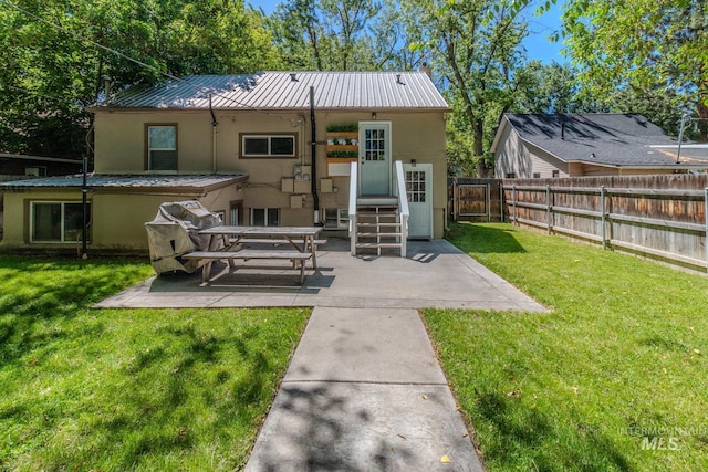 back of house featuring a lawn and a patio