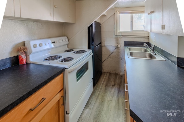 kitchen with sink, white range with electric stovetop, black fridge, and light wood-type flooring