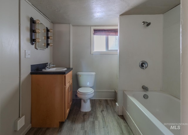 full bathroom with tub / shower combination, a textured ceiling, wood-type flooring, vanity, and toilet