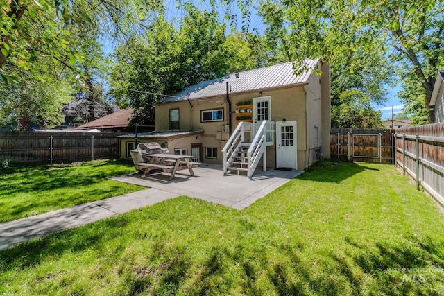 rear view of property featuring a patio and a yard