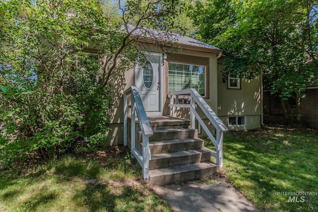 view of exterior entry featuring a yard