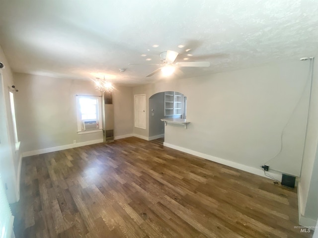 unfurnished room with a textured ceiling, dark wood-type flooring, ceiling fan with notable chandelier, and cooling unit