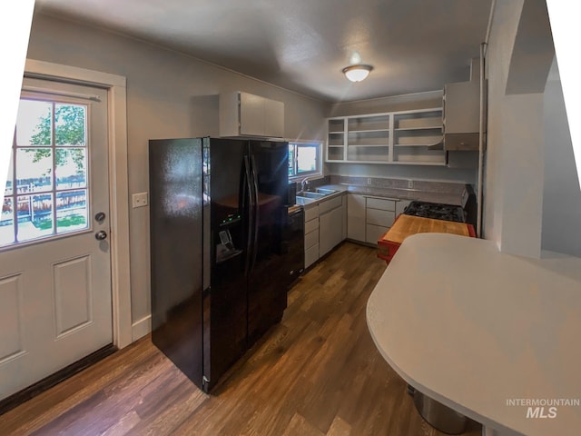 kitchen featuring black appliances, white cabinetry, dark wood-type flooring, and sink