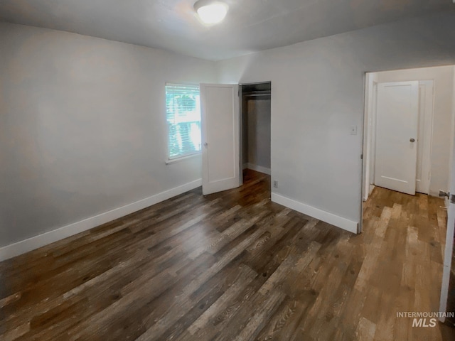 unfurnished bedroom with a closet and dark hardwood / wood-style floors