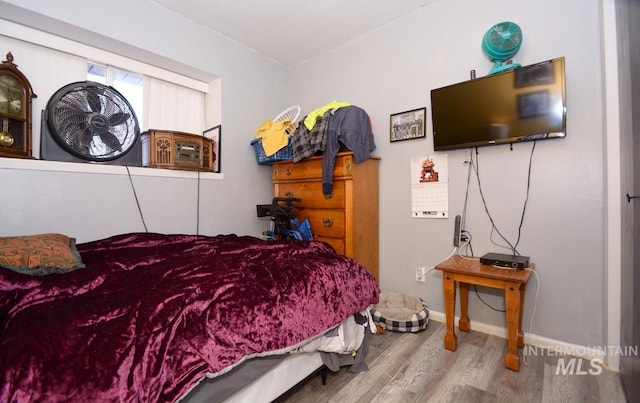 bedroom with baseboards and wood finished floors