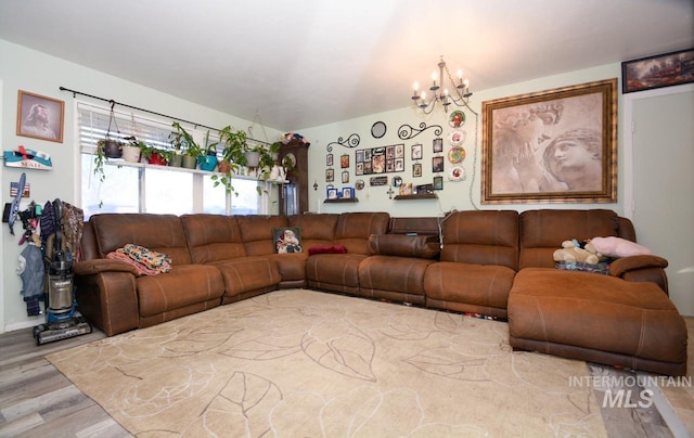 living area with wood finished floors and an inviting chandelier