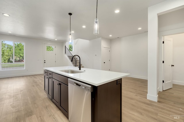 kitchen with dishwasher, sink, light hardwood / wood-style flooring, an island with sink, and decorative light fixtures