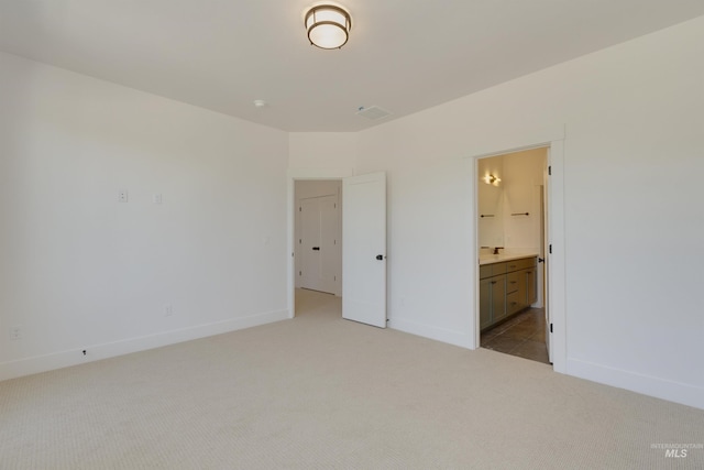 unfurnished bedroom with light carpet and ensuite bath