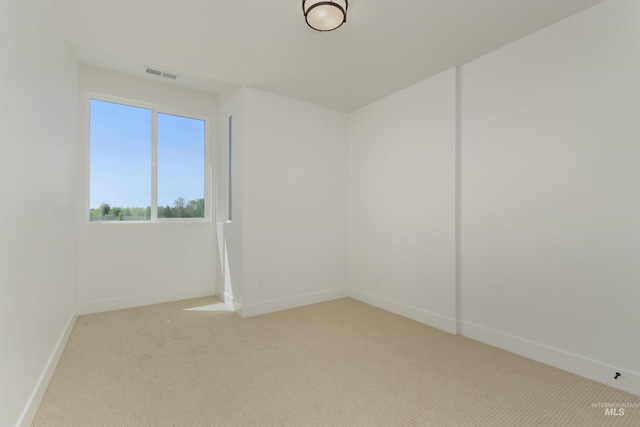 spare room featuring light colored carpet