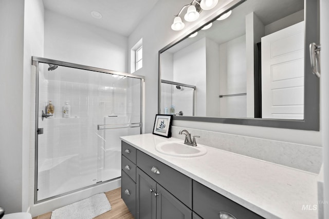 full bathroom featuring vanity, wood finished floors, and a stall shower