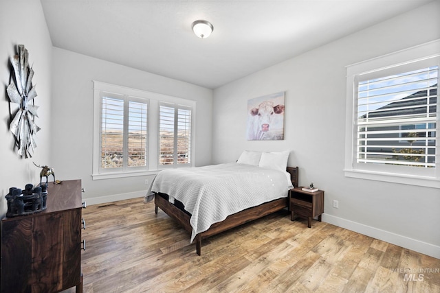 bedroom featuring visible vents, wood finished floors, and baseboards