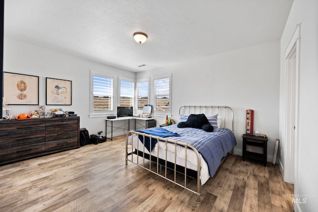 bedroom featuring baseboards and wood finished floors