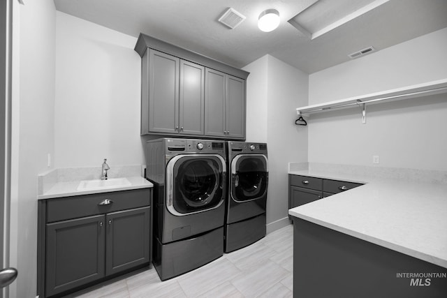 laundry room featuring independent washer and dryer, cabinet space, visible vents, and a sink