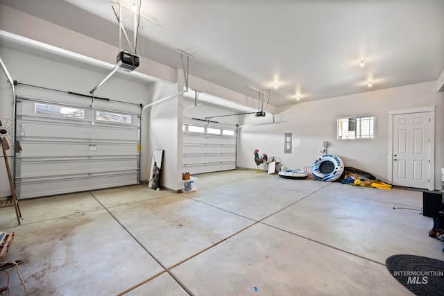 garage with electric panel and a garage door opener