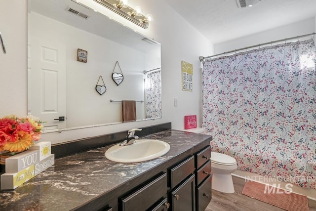 bathroom featuring vanity, toilet, curtained shower, and hardwood / wood-style floors