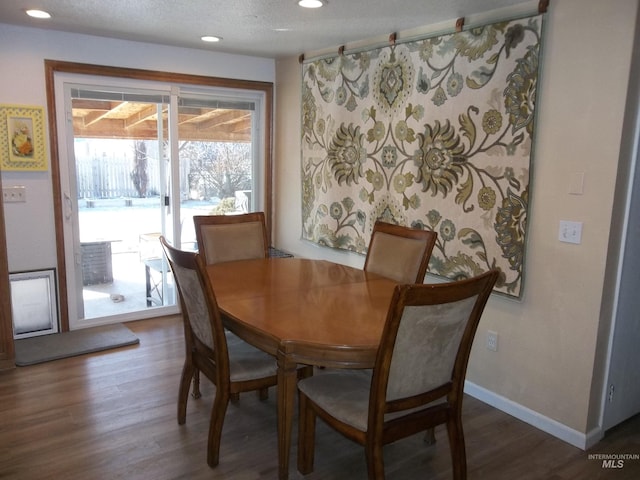 dining area with dark hardwood / wood-style flooring and a textured ceiling