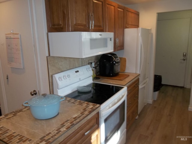 kitchen featuring white appliances and light hardwood / wood-style flooring