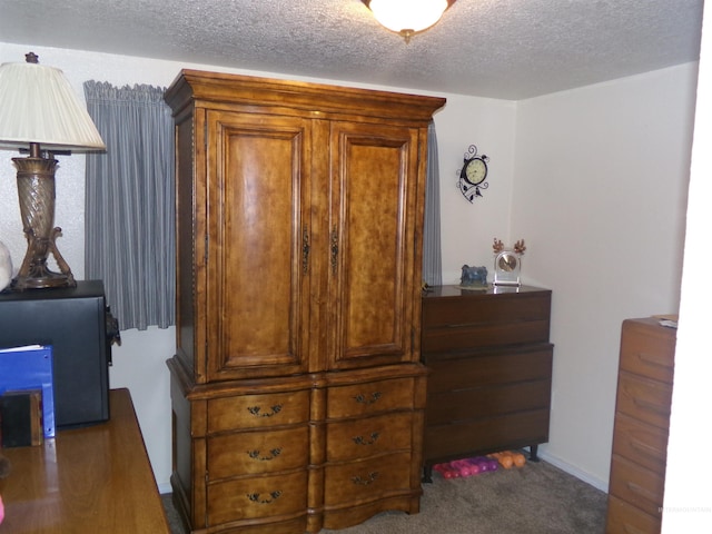 bedroom with dark carpet and a textured ceiling