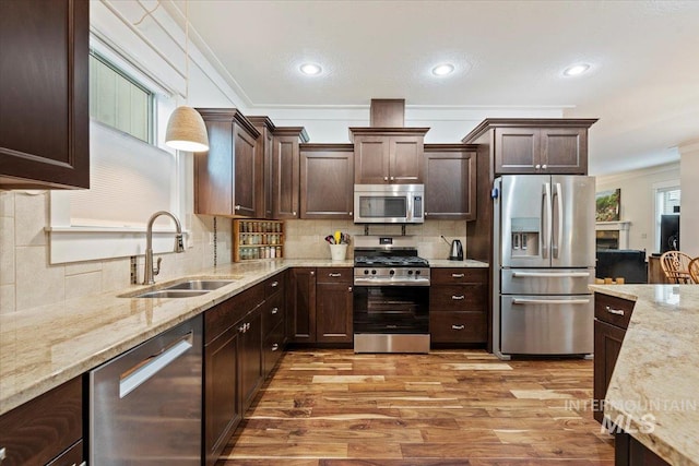 3931 N Park Crossing Ave, Meridian, ID 83646 - kitchen with appliances with stainless steel finishes, ornamental molding, dark brown cabinetry, light wood-style flooring, and recessed lighting
