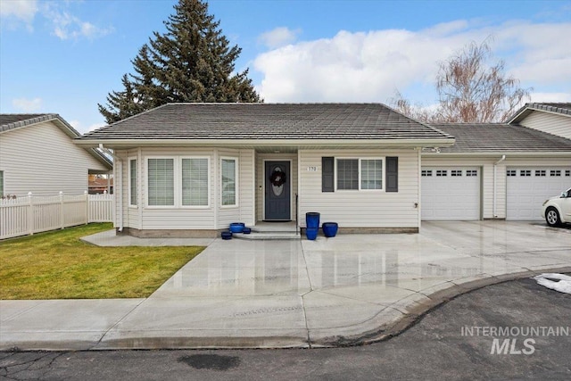 ranch-style home with a front yard, fence, a garage, driveway, and a tiled roof