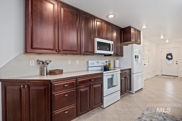 kitchen with recessed lighting, white appliances, light countertops, and light tile patterned floors