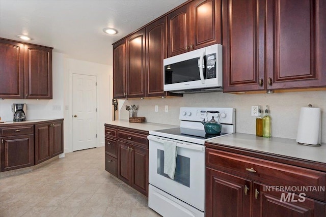 kitchen with light countertops, white appliances, backsplash, and recessed lighting