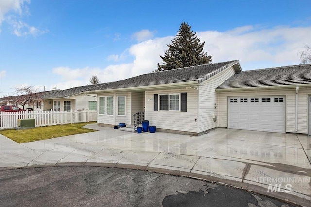 single story home with an attached garage, driveway, central air condition unit, and fence