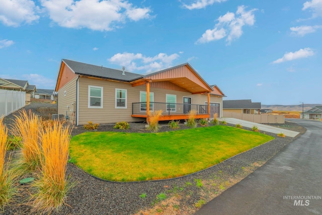 back of house featuring a wooden deck and a lawn