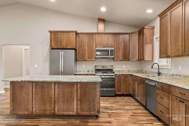 kitchen featuring dark wood-type flooring, stainless steel appliances, sink, and vaulted ceiling