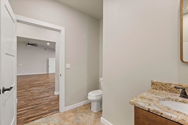 bathroom featuring vanity, toilet, wood-type flooring, and ceiling fan