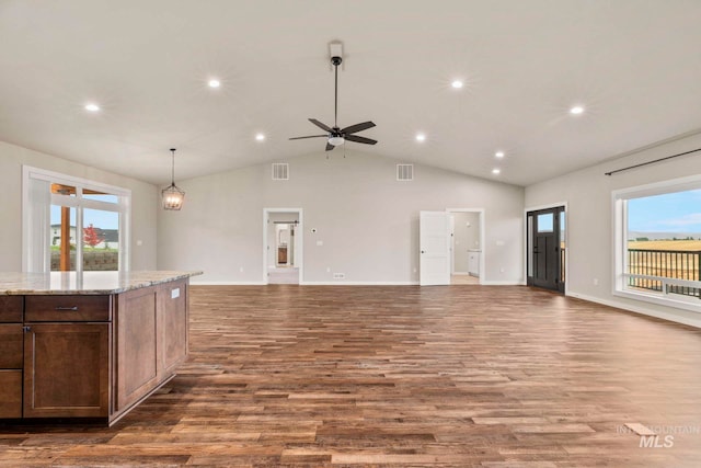 living room with high vaulted ceiling, ceiling fan with notable chandelier, wood-type flooring, and a healthy amount of sunlight