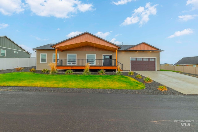 view of front of house with a deck, a front yard, and a garage