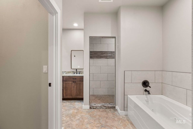 bathroom featuring vanity and independent shower and bath