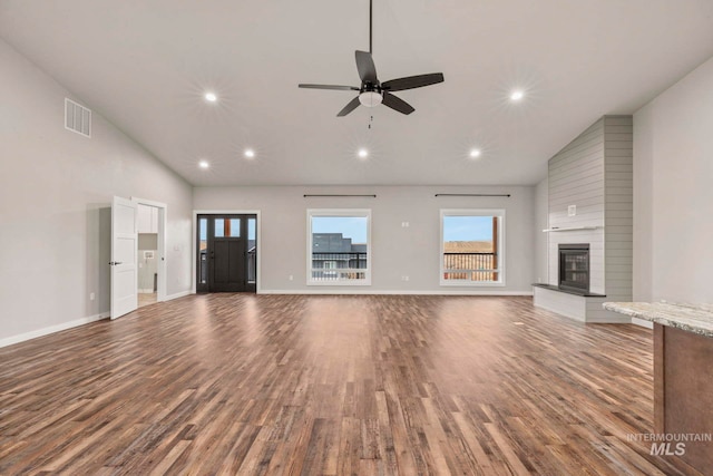 unfurnished living room featuring ceiling fan, high vaulted ceiling, a fireplace, and hardwood / wood-style floors