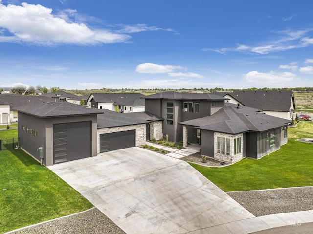 prairie-style home featuring a garage, driveway, a residential view, and a front yard