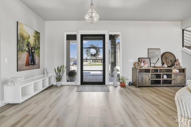 entrance foyer with light wood-type flooring and an inviting chandelier