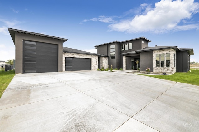 view of front of home featuring an attached garage, stone siding, concrete driveway, stucco siding, and a front lawn