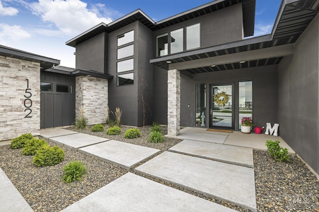 property entrance with stone siding and stucco siding