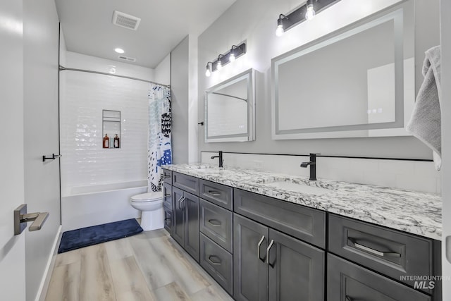 full bathroom with visible vents, a sink, toilet, and shower / bath combo with shower curtain