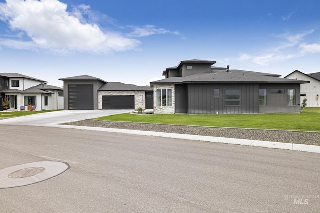 prairie-style house featuring concrete driveway, a residential view, an attached garage, a front lawn, and board and batten siding